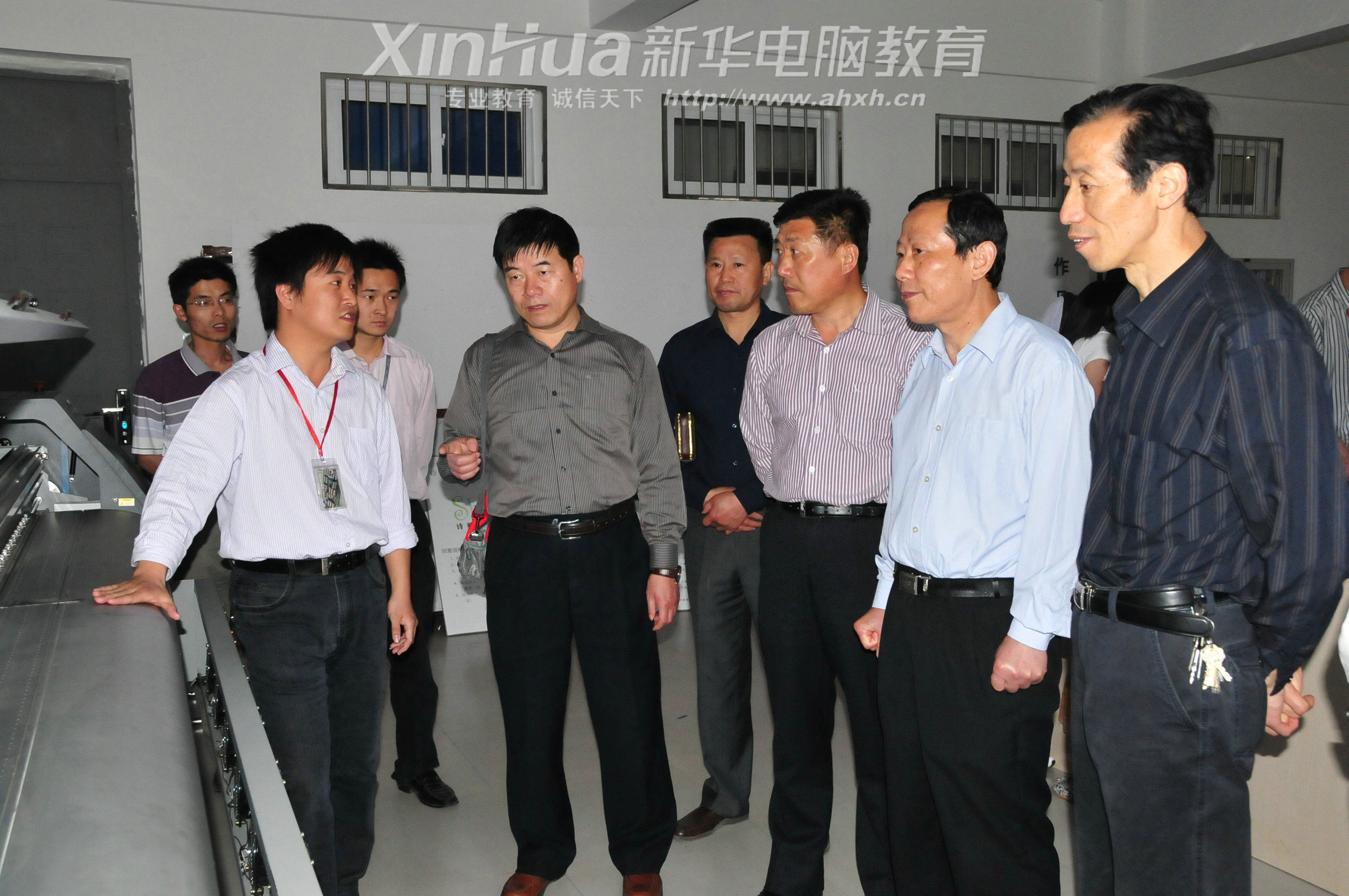 安徽新華電腦專修學院_安徽新華電腦專修學院實訓項目負責人正在為瑤海區政協領導做設備操作講解